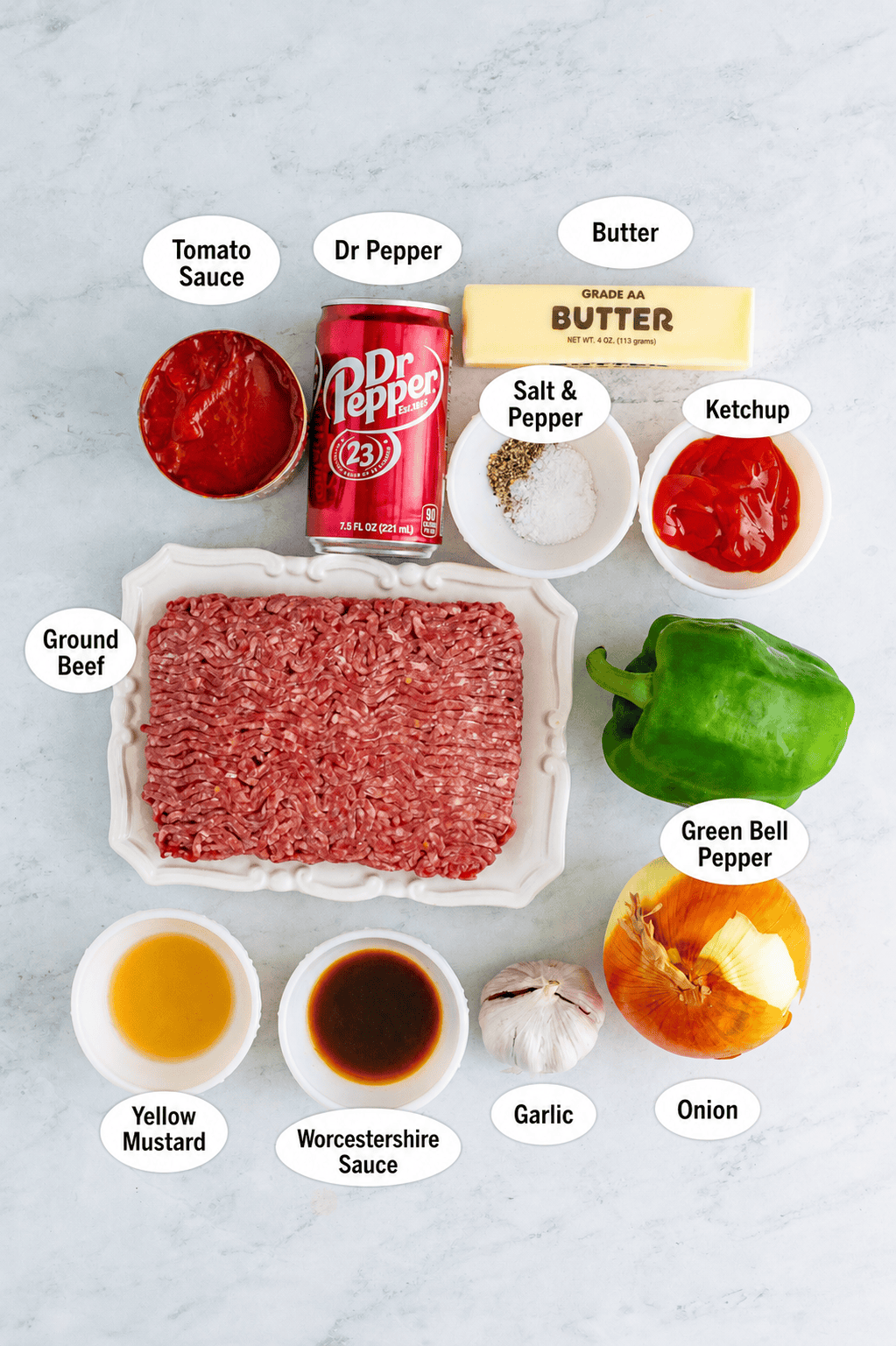 All labeled Dr Pepper sloppy joes ingredients arranged on marble, including ground beef, Dr Pepper, tomato sauce, ketchup, onion, garlic, and green bell pepper.