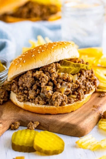 Best Copycat Maid Rite Recipe loose meat sandwich on a bun with dill pickle chips ready to serve.