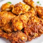 Close up of golden Crispy Southern Fried Chicken on a wire rack with steam rising from the seasoned crust.