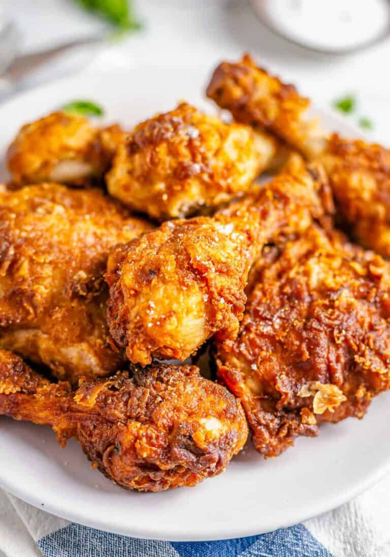 Close up of golden Crispy Southern Fried Chicken on a wire rack with steam rising from the seasoned crust.
