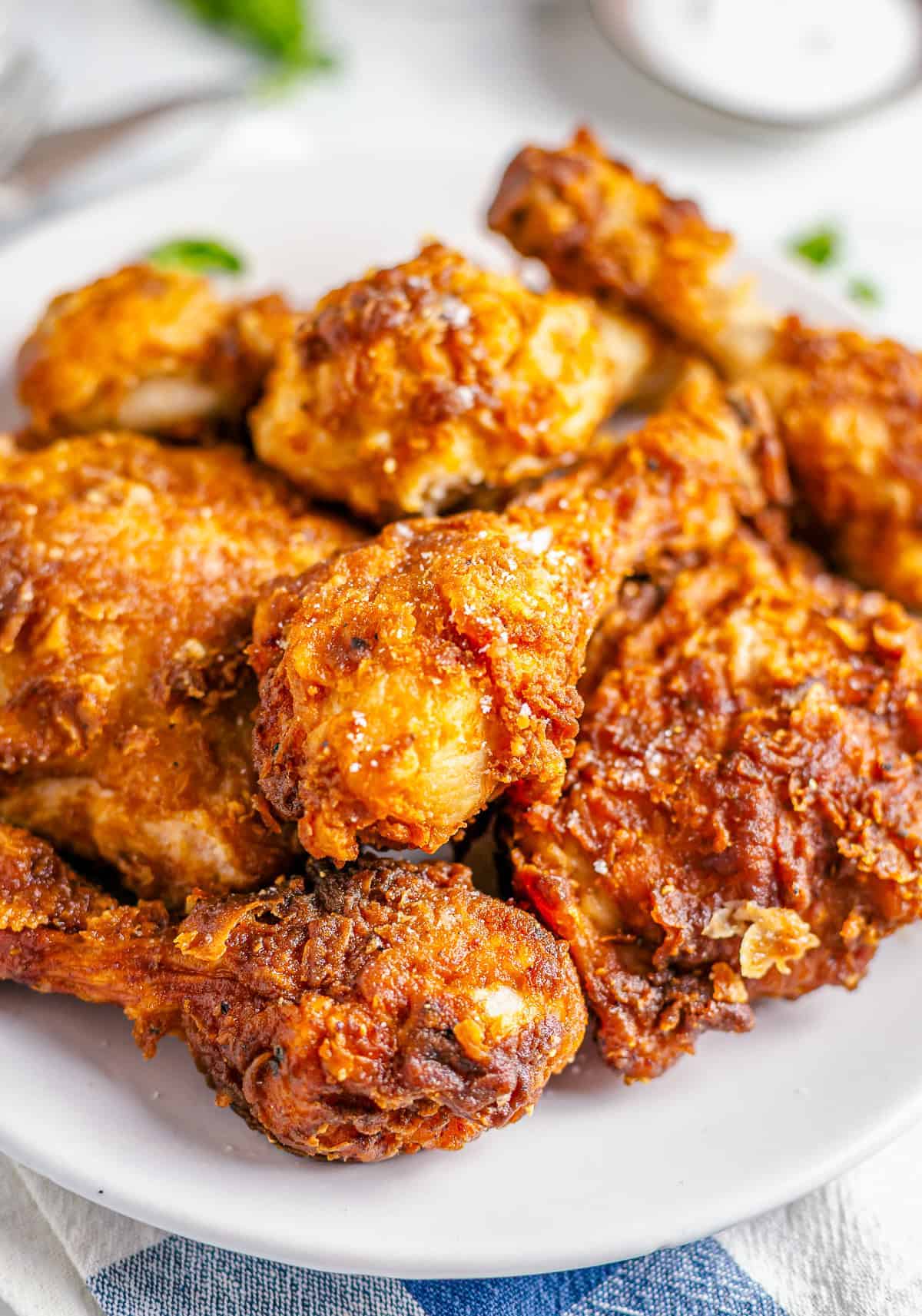 Close up of golden Crispy Southern Fried Chicken on a wire rack with steam rising from the seasoned crust.