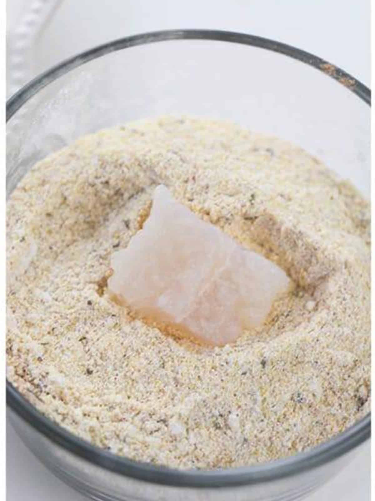 Catfish nugget dredged in the seasoned cornmeal mixture for Air Fryer Catfish Nuggets.