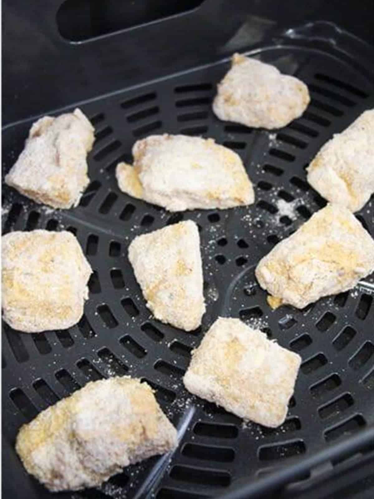 Breaded Air Fryer Catfish Nuggets arranged in the air fryer basket.