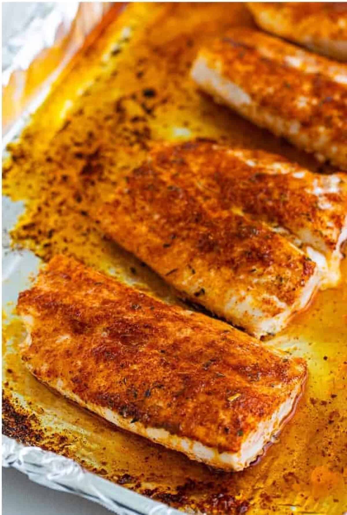 Brushing melted butter on Mahi Mahi Recipe fillets and sprinkling the spice rub on top.