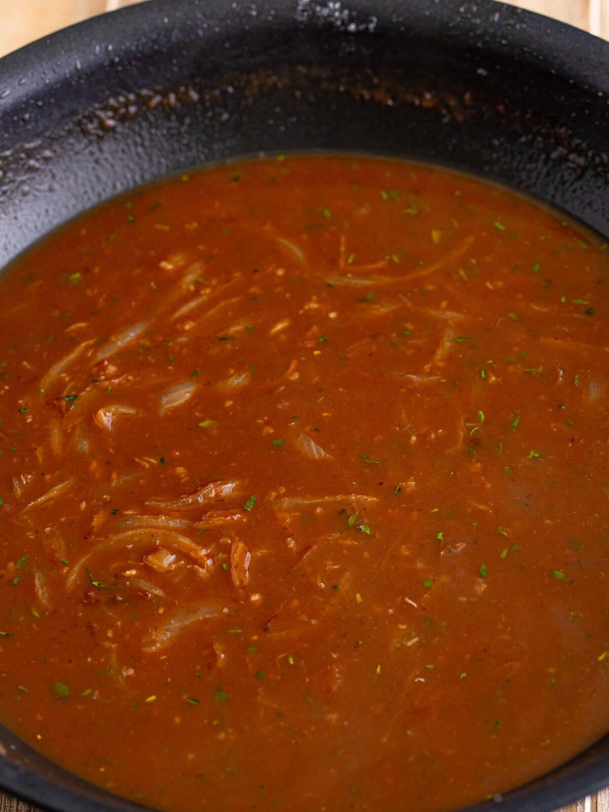 Beef gravy simmering with stock, wine, and steak sauce for beef tips and noodles.