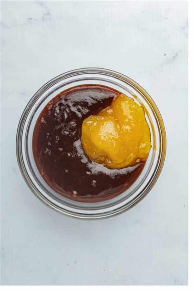 Small glass bowl with BBQ sauce and a dollop of honey ready to be whisked together for Best Oven St Louis Ribs Recipe.