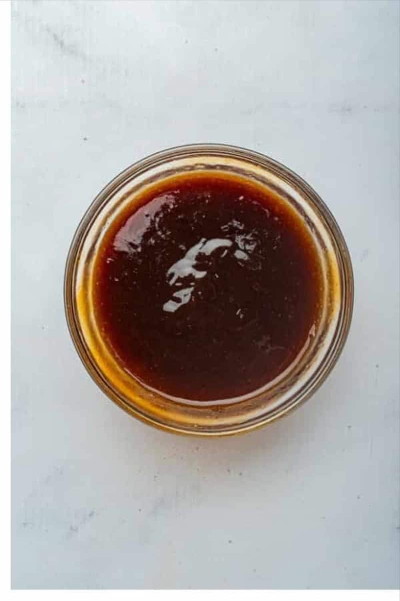 Small glass bowl with BBQ sauce and honey whisked together into a smooth glaze for Best Oven St Louis Ribs Recipe.