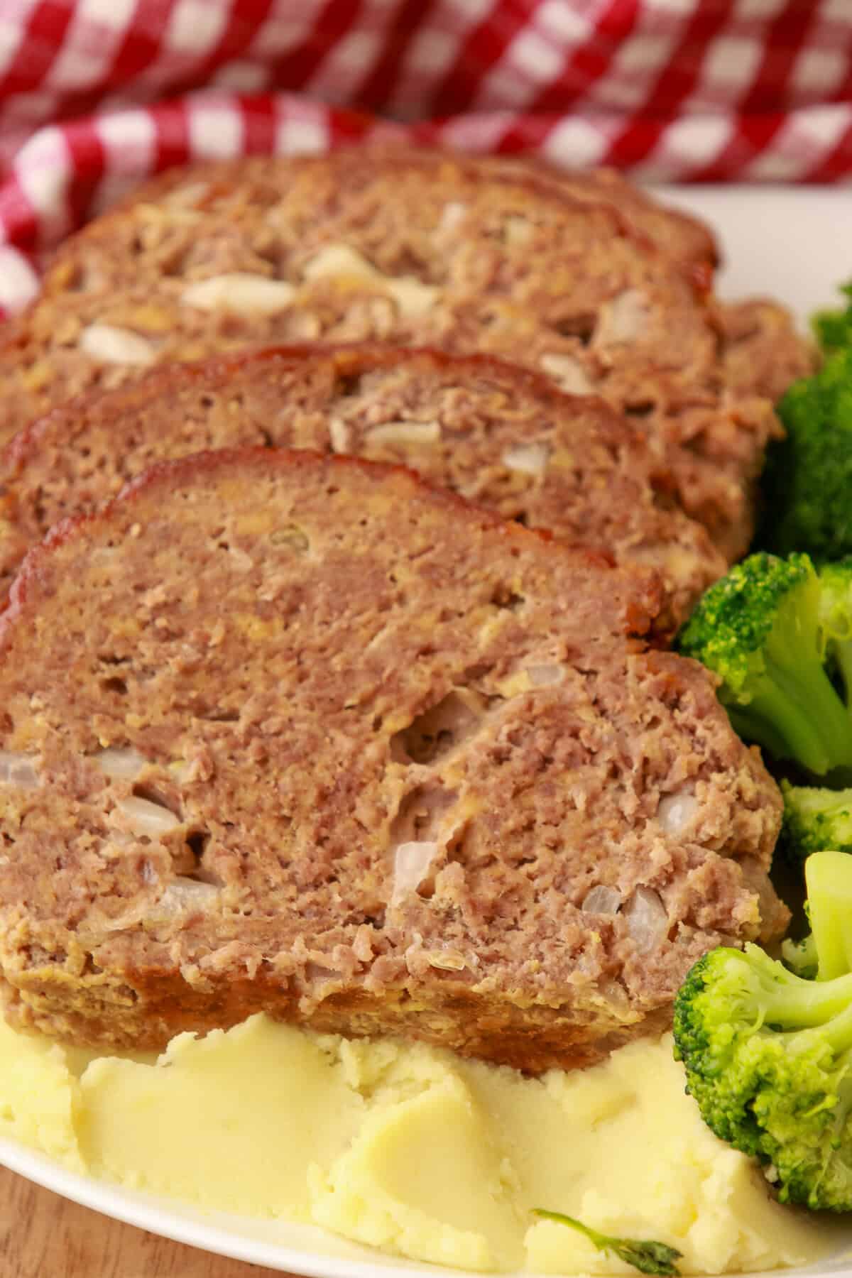Cheesy meatloaf cut open showing tender beef and melted Chedz inside.
