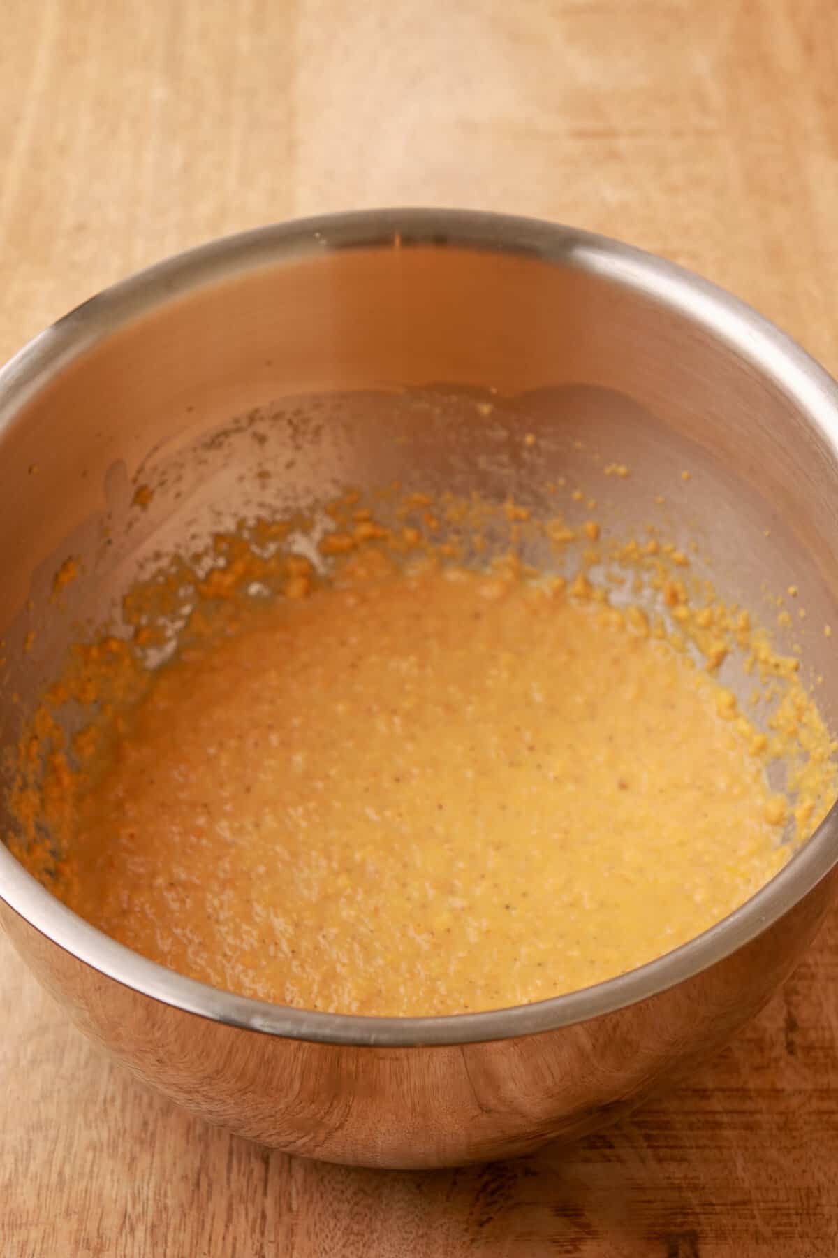 Eggs, milk, salt, pepper, and Chedz crumbs whisked in a glass bowl.