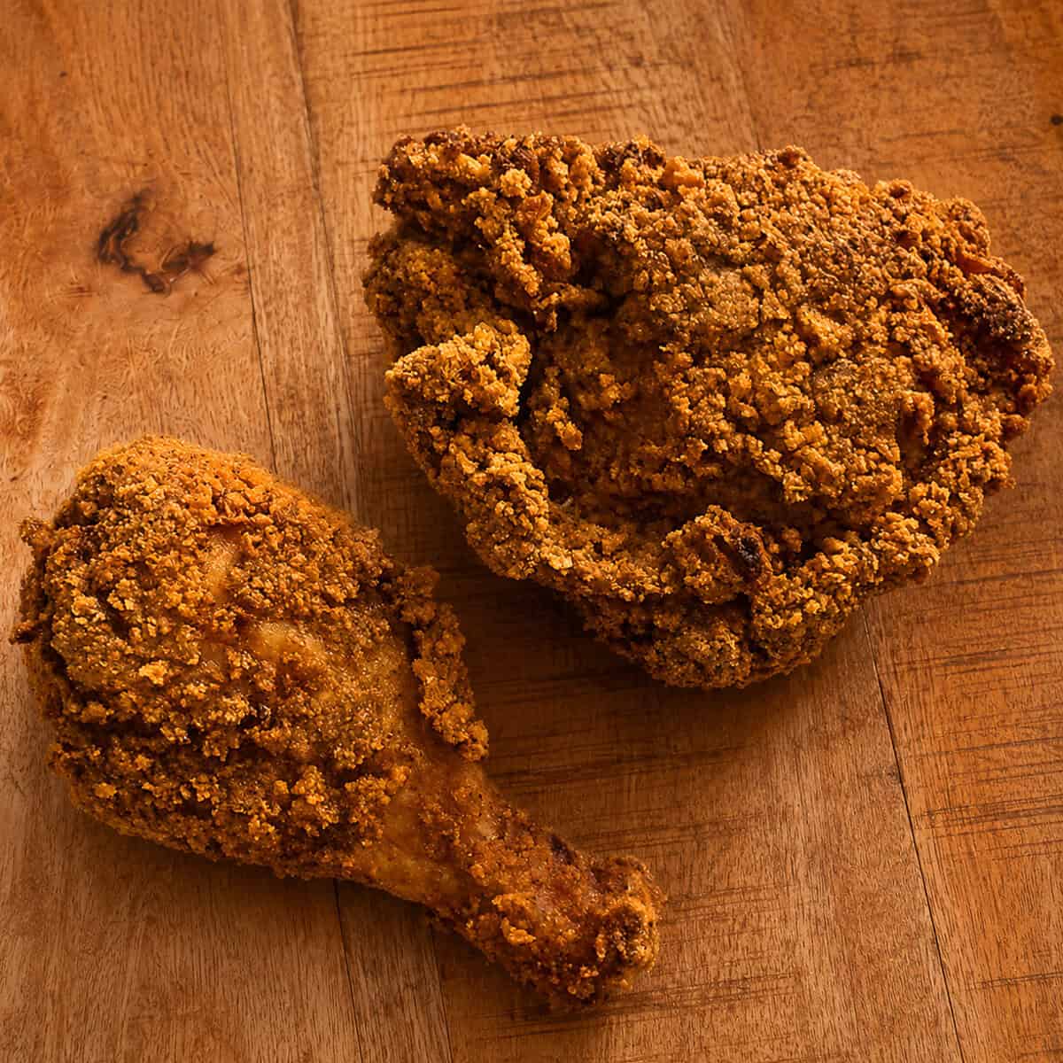 Cheesy fried chicken pieces with golden Chedz cracker crust on a serving plate.