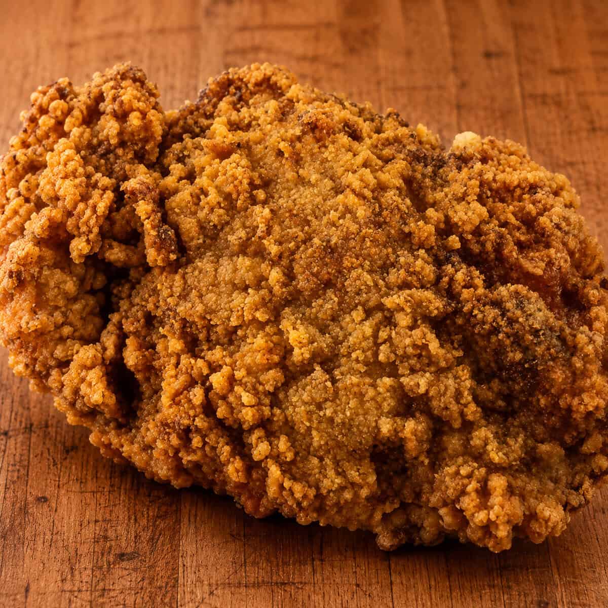 Cheesy fried chicken cut open to show juicy meat under a crispy Chedz crust.