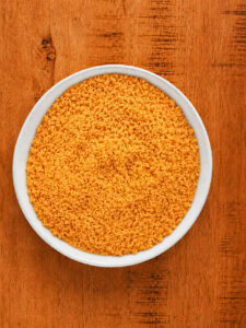 Ground Chedz cheese cracker crumbs mixed with black pepper in a large bowl.