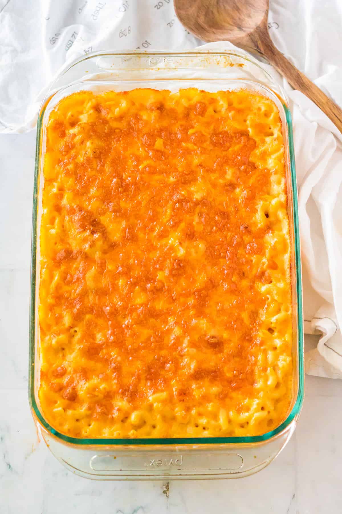 Baked Chick Fil A Mac and Cheese Recipe in a glass Pyrex dish with a golden bubbling cheddar top.