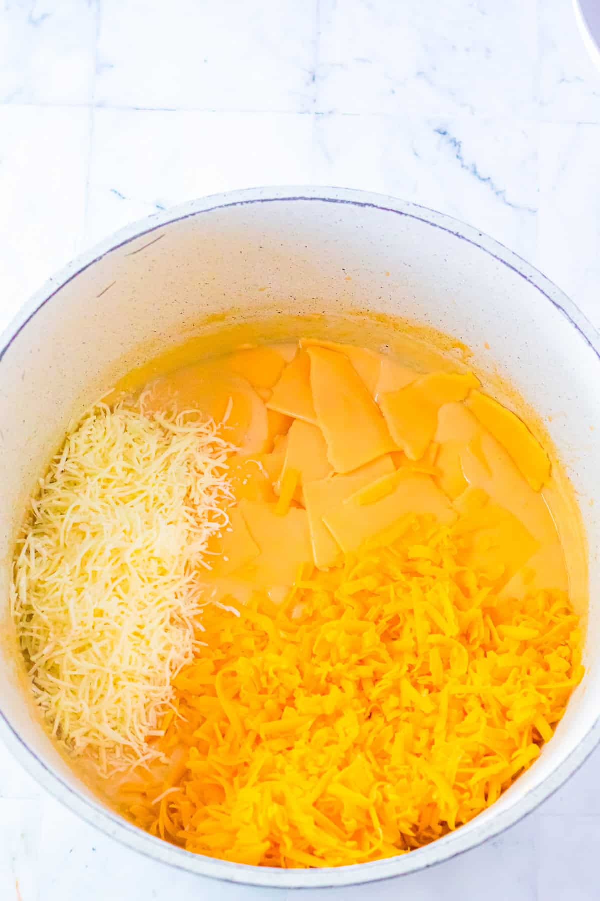 American cheese slices, shredded sharp cheddar, and Italian blend cheese added to the milk mixture for Chick Fil A Mac and Cheese Recipe.
