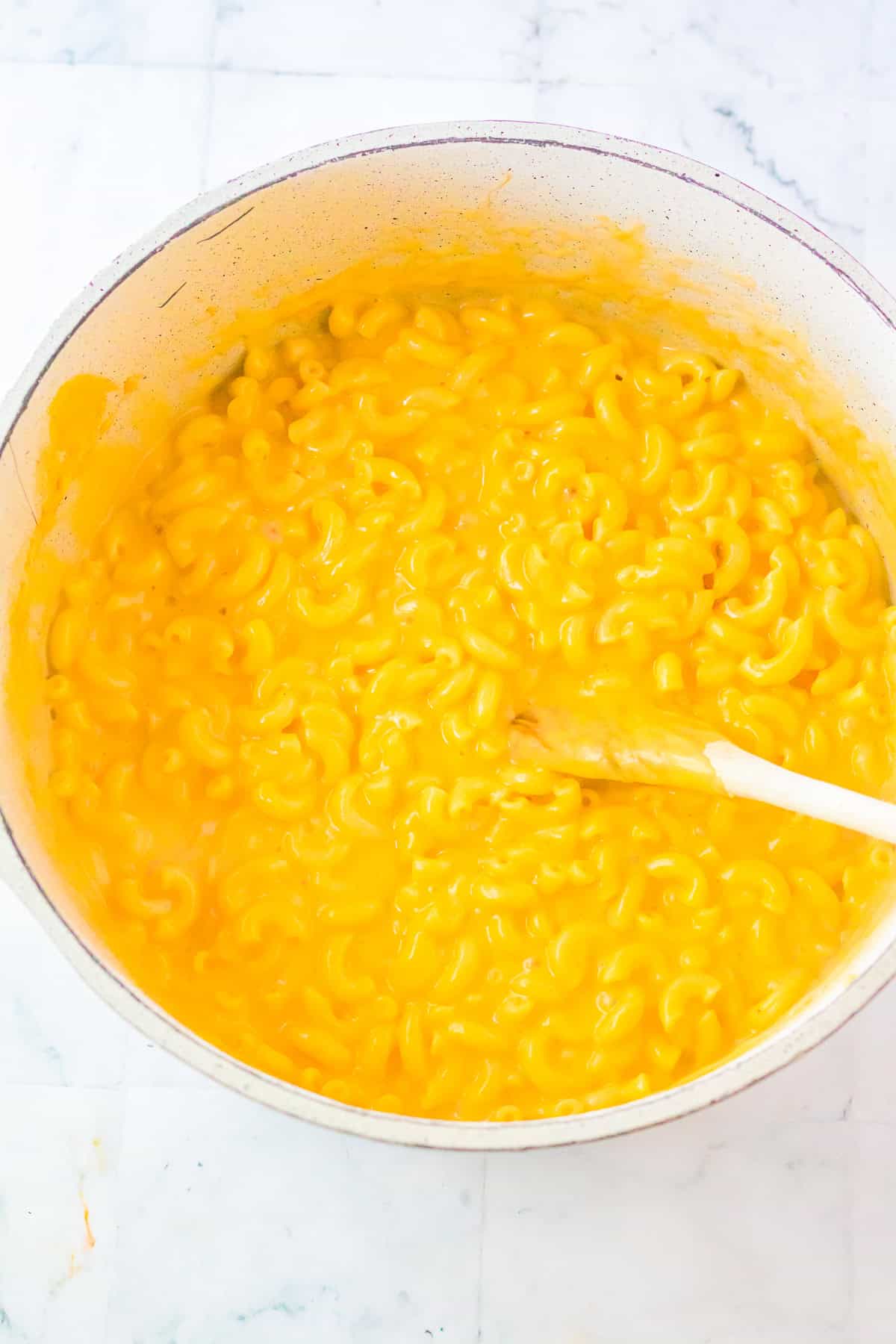 Cooked elbow macaroni folded into creamy cheese sauce for Chick Fil A Mac and Cheese Recipe.