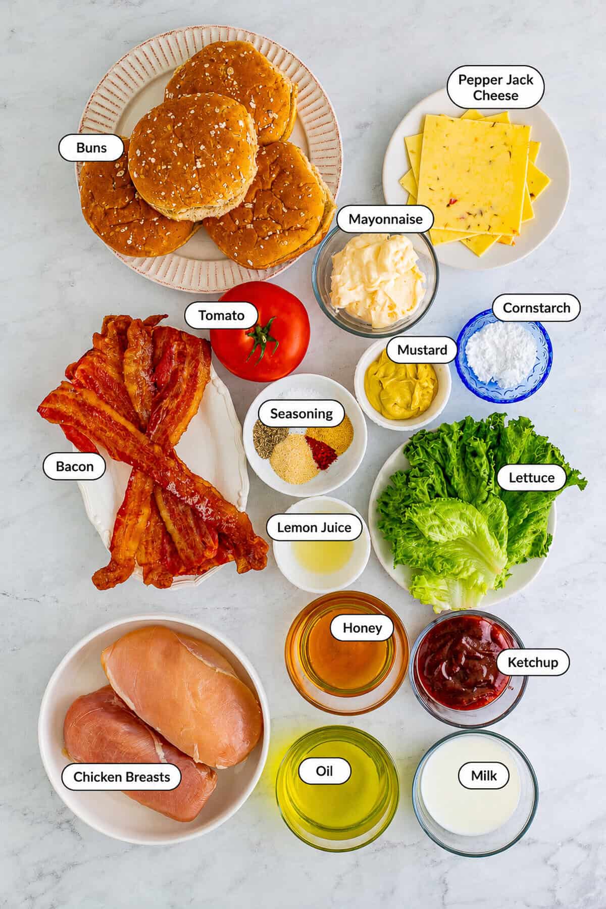 Labeled Chick Fil A grilled chicken sandwich ingredients including chicken breasts buns pepper jack cheese bacon lettuce tomato honey roasted bbq sauce and pickle juice marinade fixings.