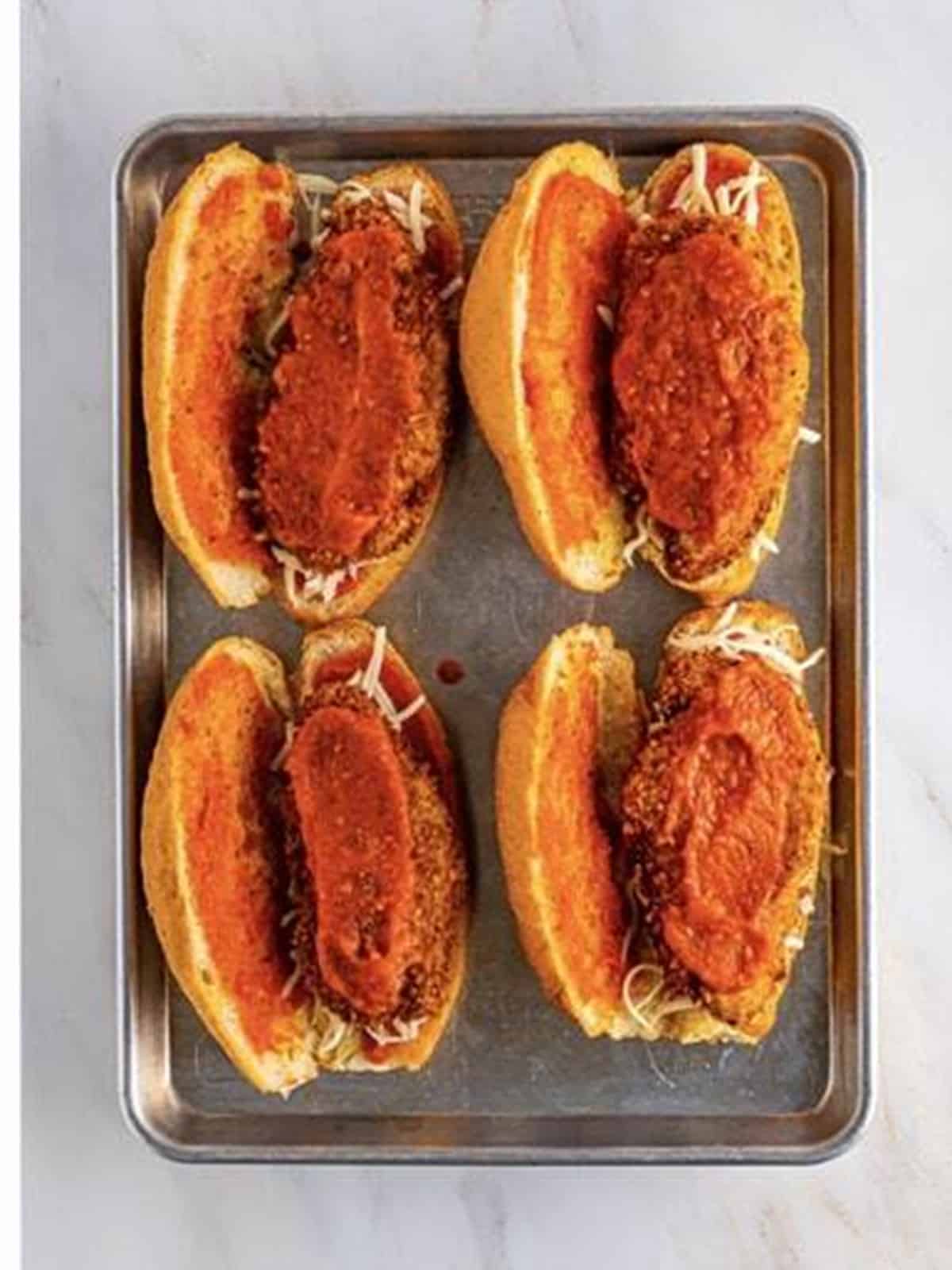 Crispy chicken cutlets layered onto hoagie rolls with marinara for chicken parmesan sandwiches.