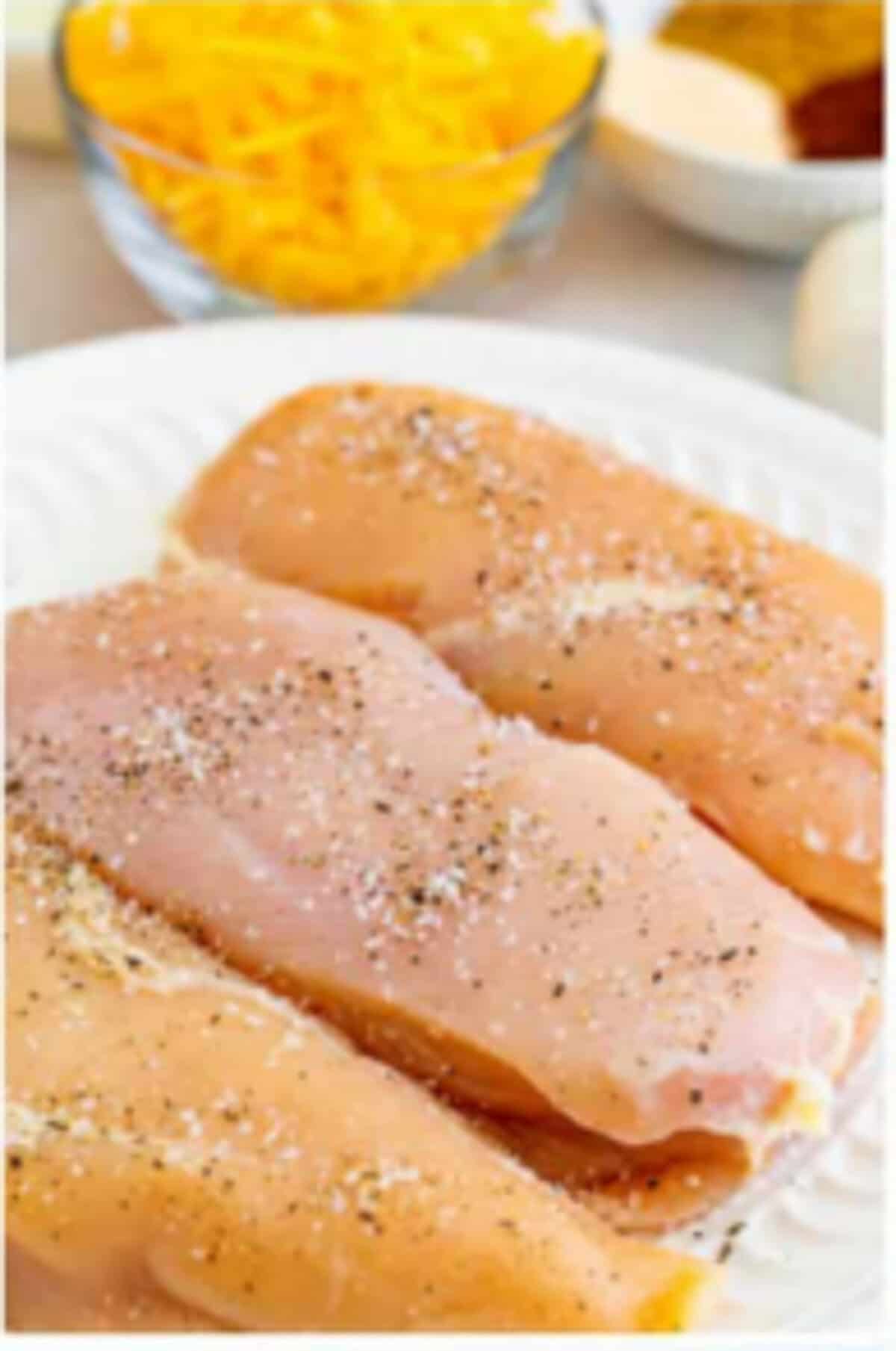 Chicken breasts seasoned with kosher salt and black pepper ready to sear for Copycat Chili Chicken Enchilada Soup.