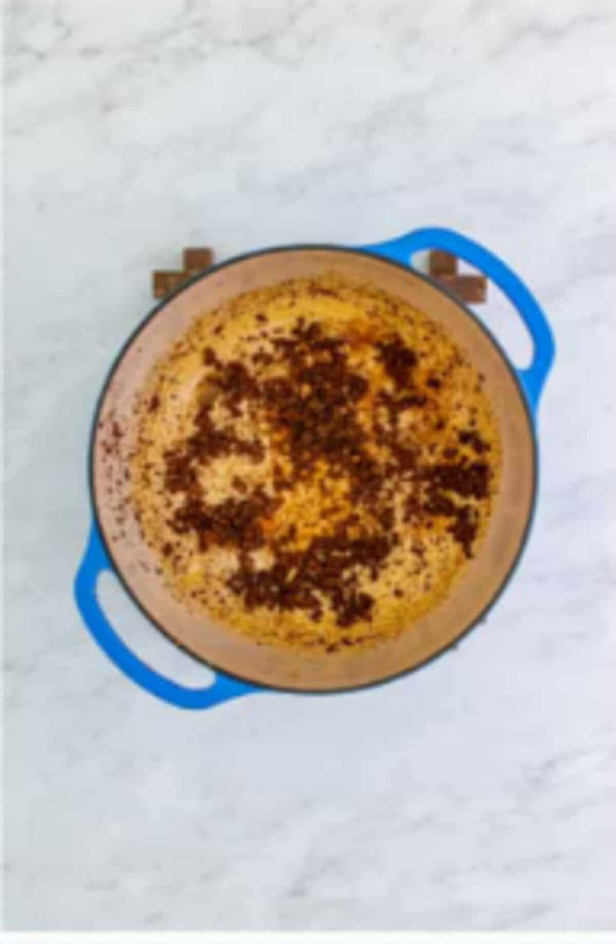 Garlic chili powder cumin and onion powder added to the Dutch oven cooking until fragrant for Copycat Chili Chicken Enchilada Soup.