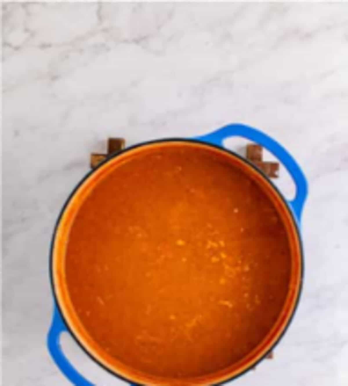 Bowl of Copycat Chili Chicken Enchilada Soup served with extra cheese tortilla strips fresh cilantro and a dollop of sour cream.