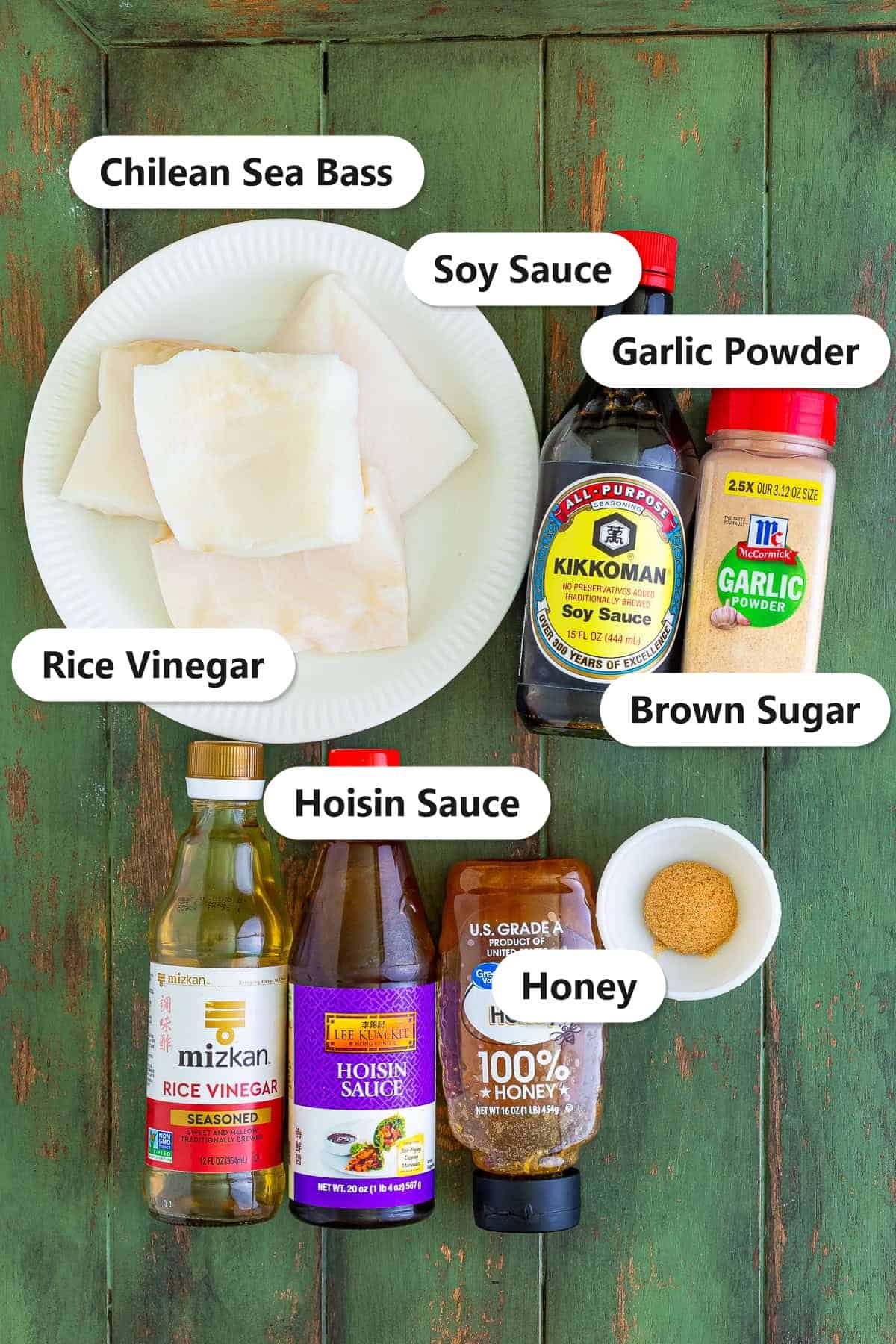 Chilean Sea Bass Recipe ingredients labeled on a green board including sea bass filets, soy sauce, garlic powder, rice vinegar, hoisin sauce, honey, and brown sugar.