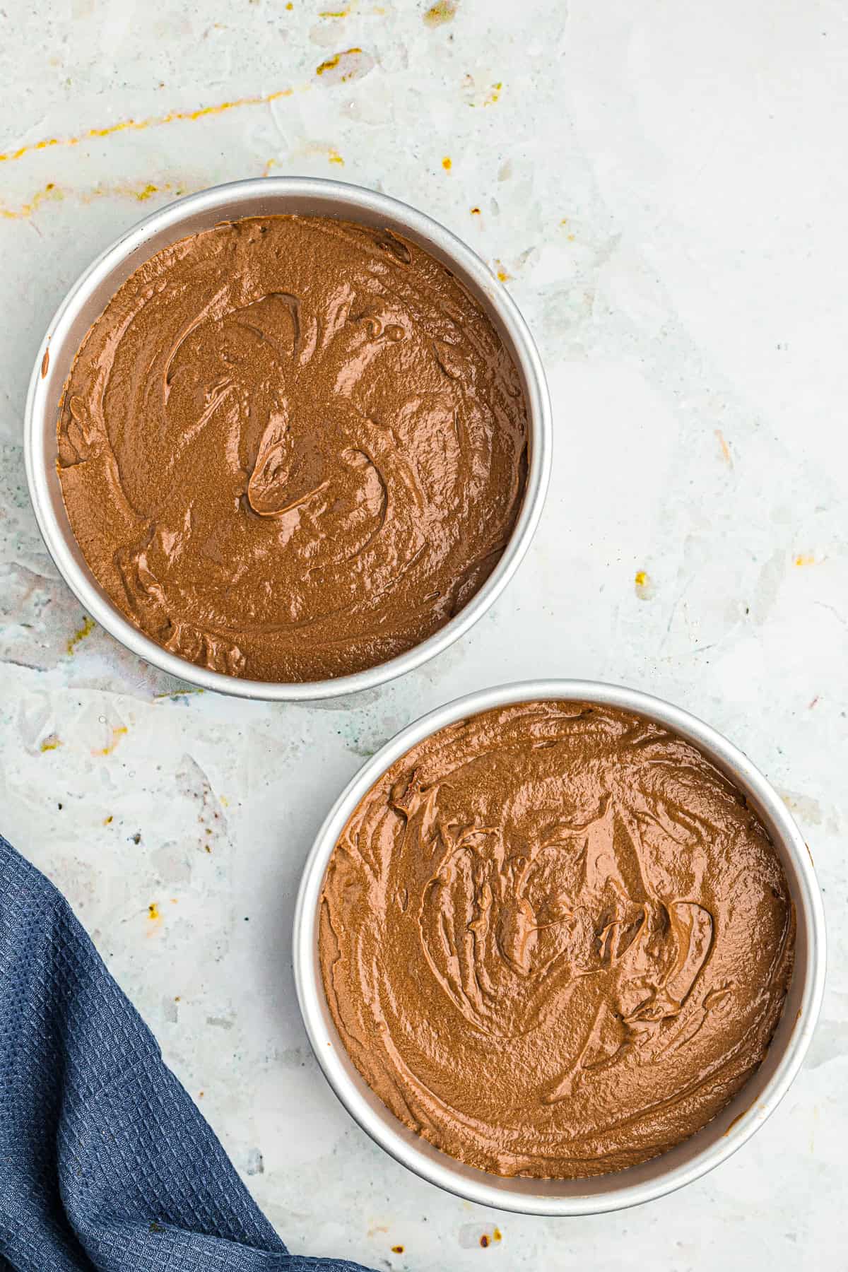 Two 8 inch cake pans filled with Chocolate Espresso Cake batter ready for the oven.