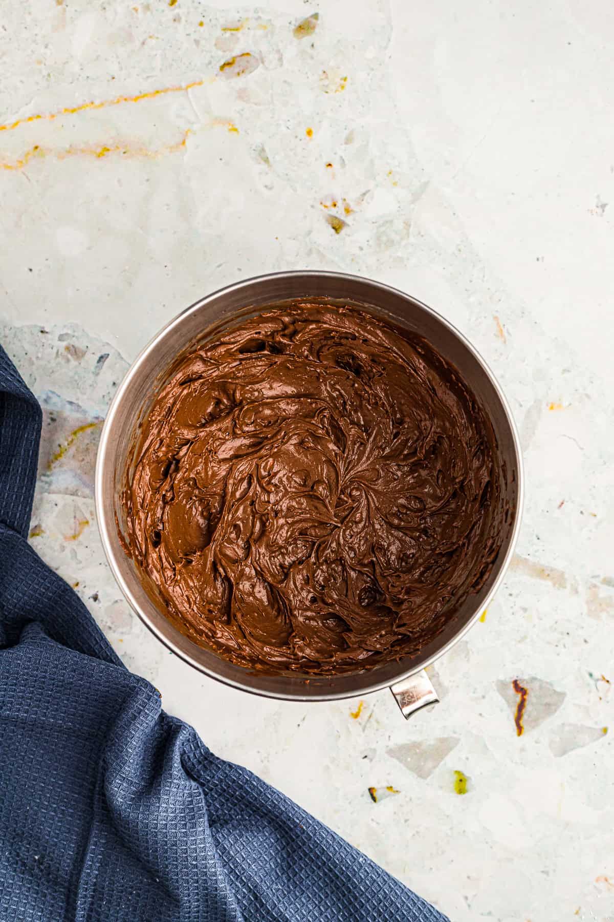 Whipped chocolate buttercream frosting for Chocolate Espresso Cake in a stand mixer bowl.