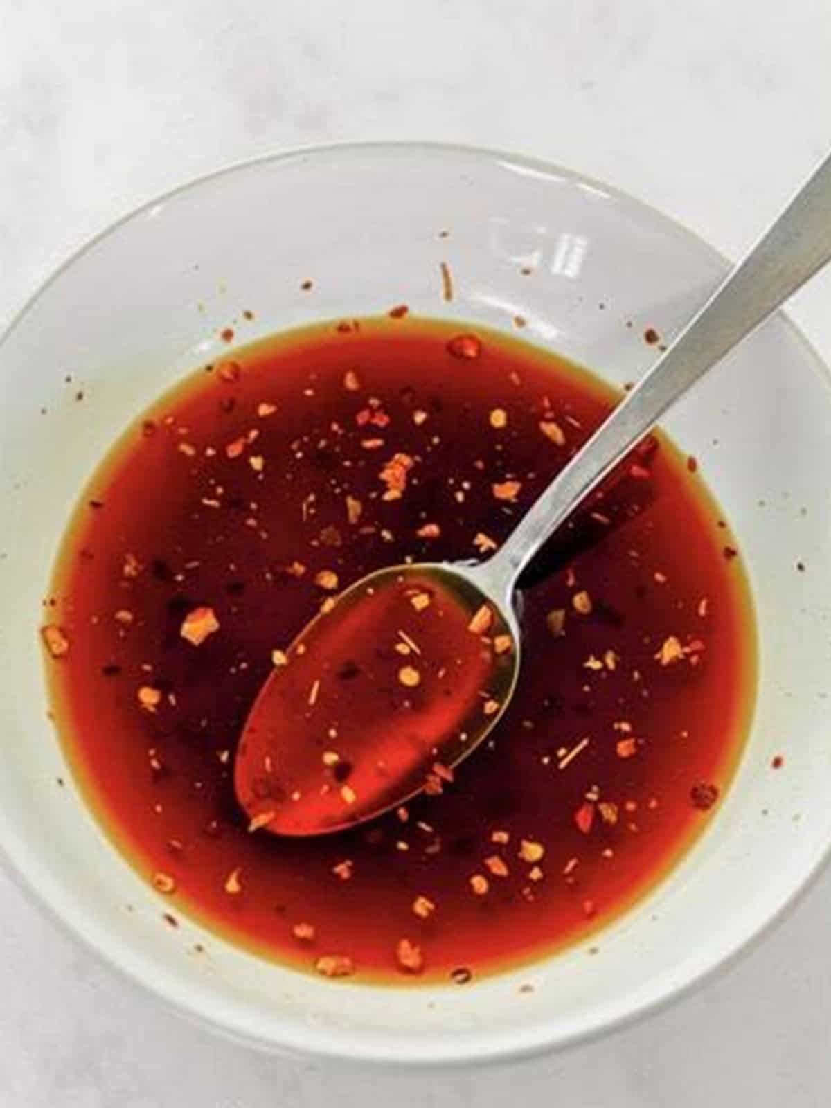 Teriyaki sauce with sesame oil and red pepper flakes whisked in a bowl for Chow Mein with Ramen Noodles.