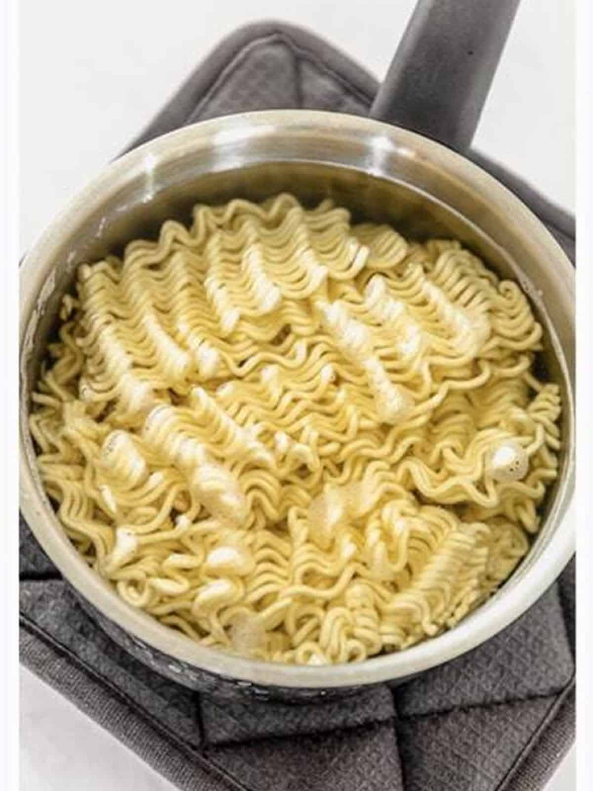 Ramen noodles softening in a pot of hot water.
