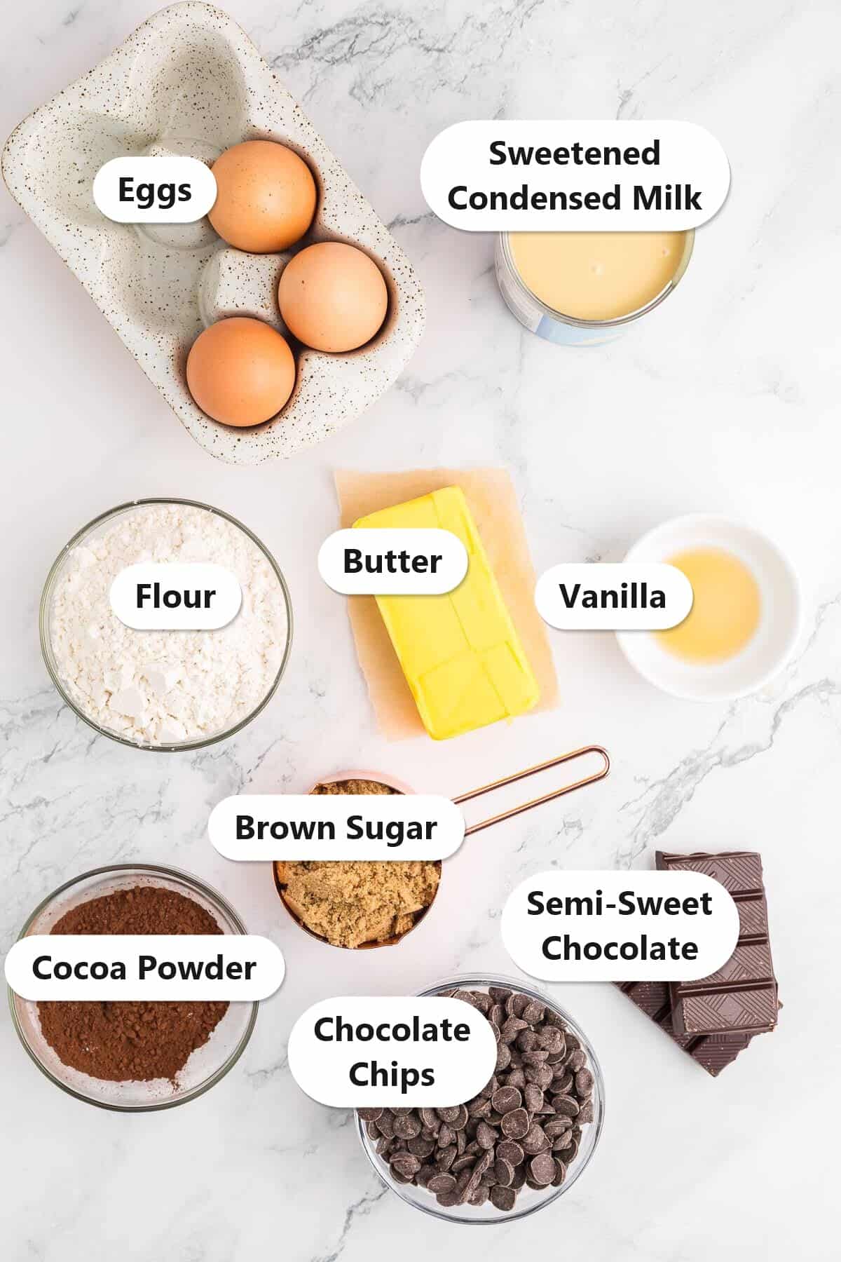 Labeled ingredients to make condensed milk brownies including sweetened condensed milk, butter, semi-sweet chocolate, brown sugar, eggs, flour, cocoa powder, and chocolate chips.