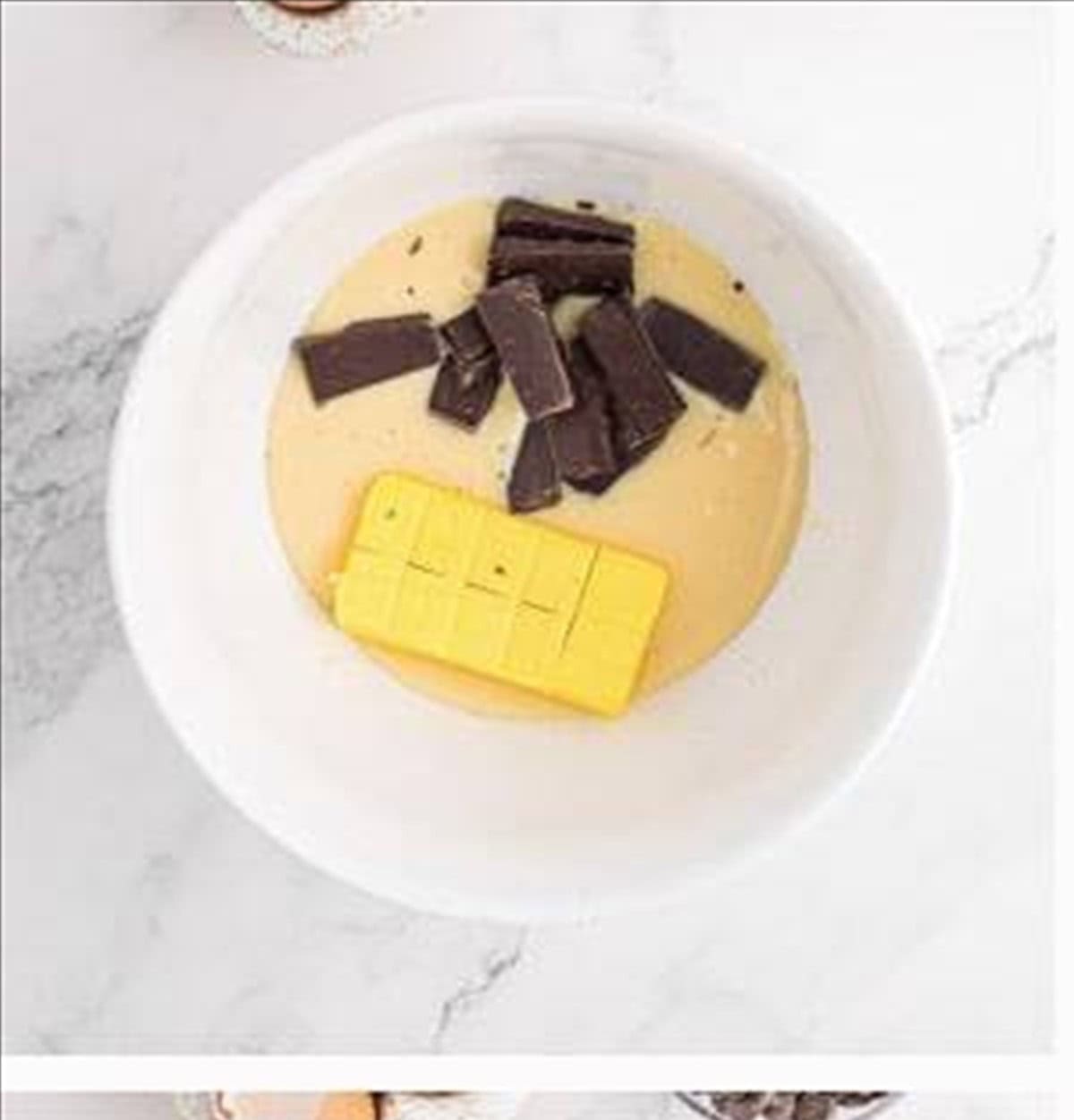 Sweetened condensed milk, butter, and chopped chocolate melted together in a bowl.