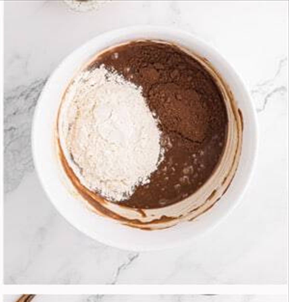 Flour and cocoa powder added to the brownie batter.