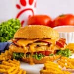 Finished Copycat Chick Fil A Grilled Chicken Sandwich Recipe layered with bacon, cheese, lettuce, and tomato on a multigrain bun.