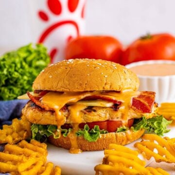 Finished Copycat Chick Fil A Grilled Chicken Sandwich Recipe layered with bacon, cheese, lettuce, and tomato on a multigrain bun.