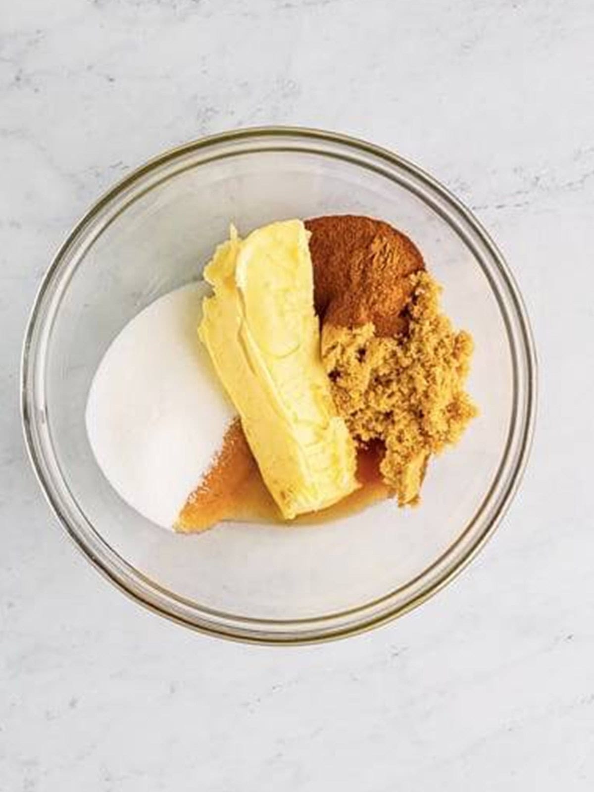 Butter, sugars, cinnamon, and vanilla in a bowl for the cinnamon roll filling.