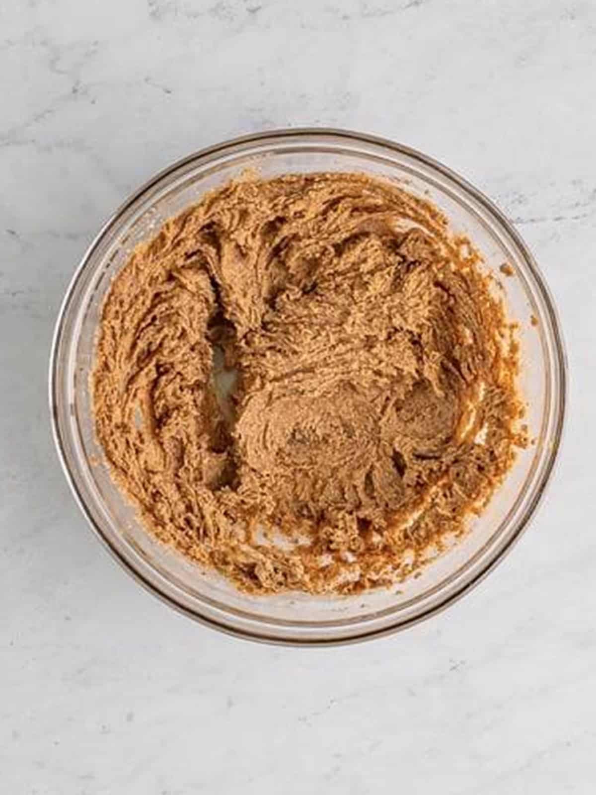 The cinnamon roll filling mixed smooth in a glass bowl.
