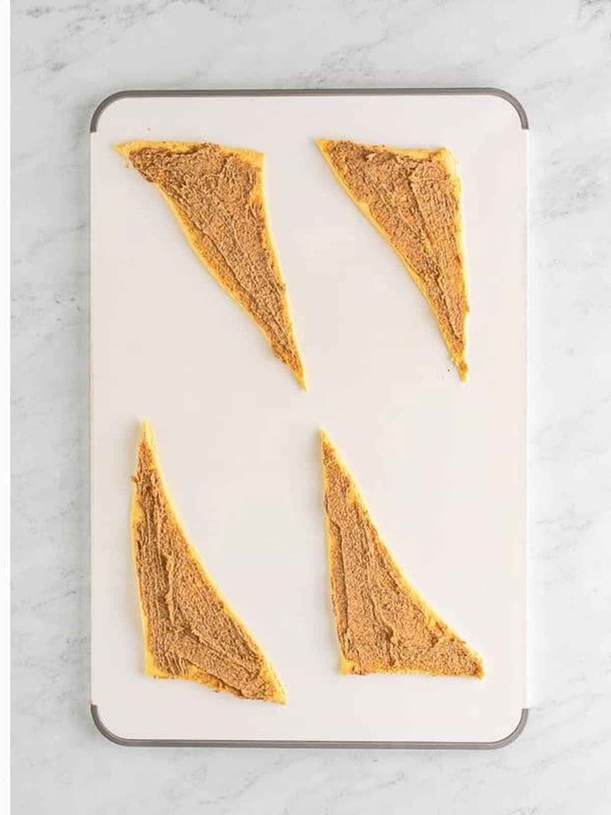Cinnamon filling spread over the crescent dough triangles.