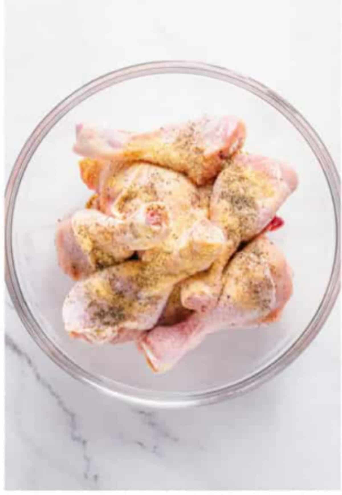 Seasoning chicken pieces with kosher salt black pepper garlic powder and onion powder for Crispy Southern Fried Chicken.