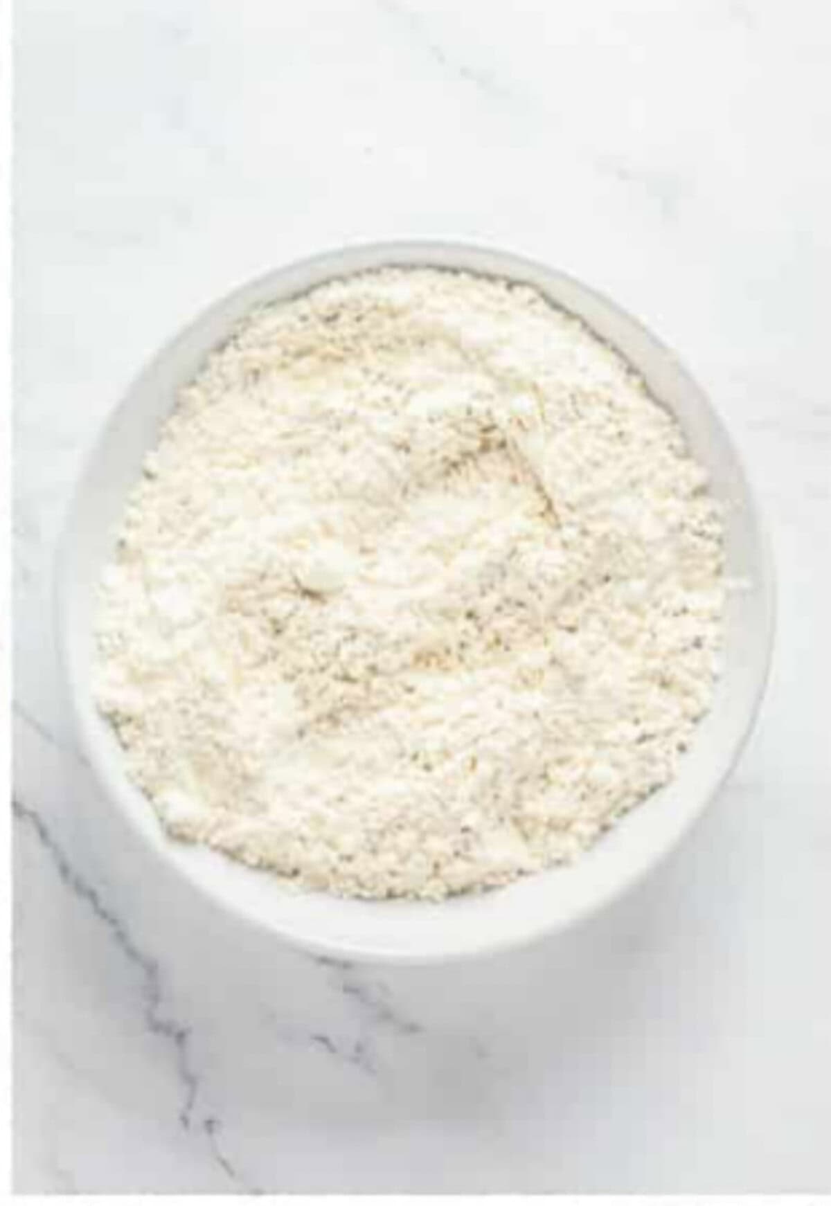 Self rising flour and black pepper whisked together in a shallow bowl for the dredge for Crispy Southern Fried Chicken.