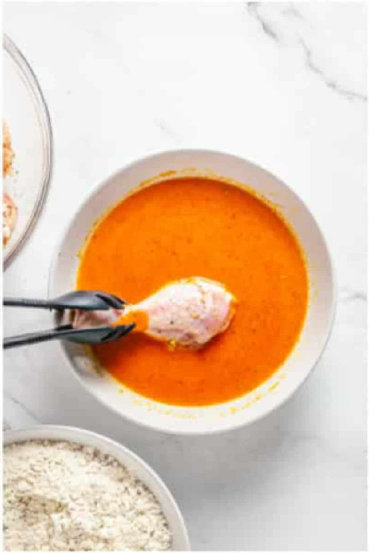 Dipping seasoned chicken into the egg wash and then coating in seasoned flour for Crispy Southern Fried Chicken.