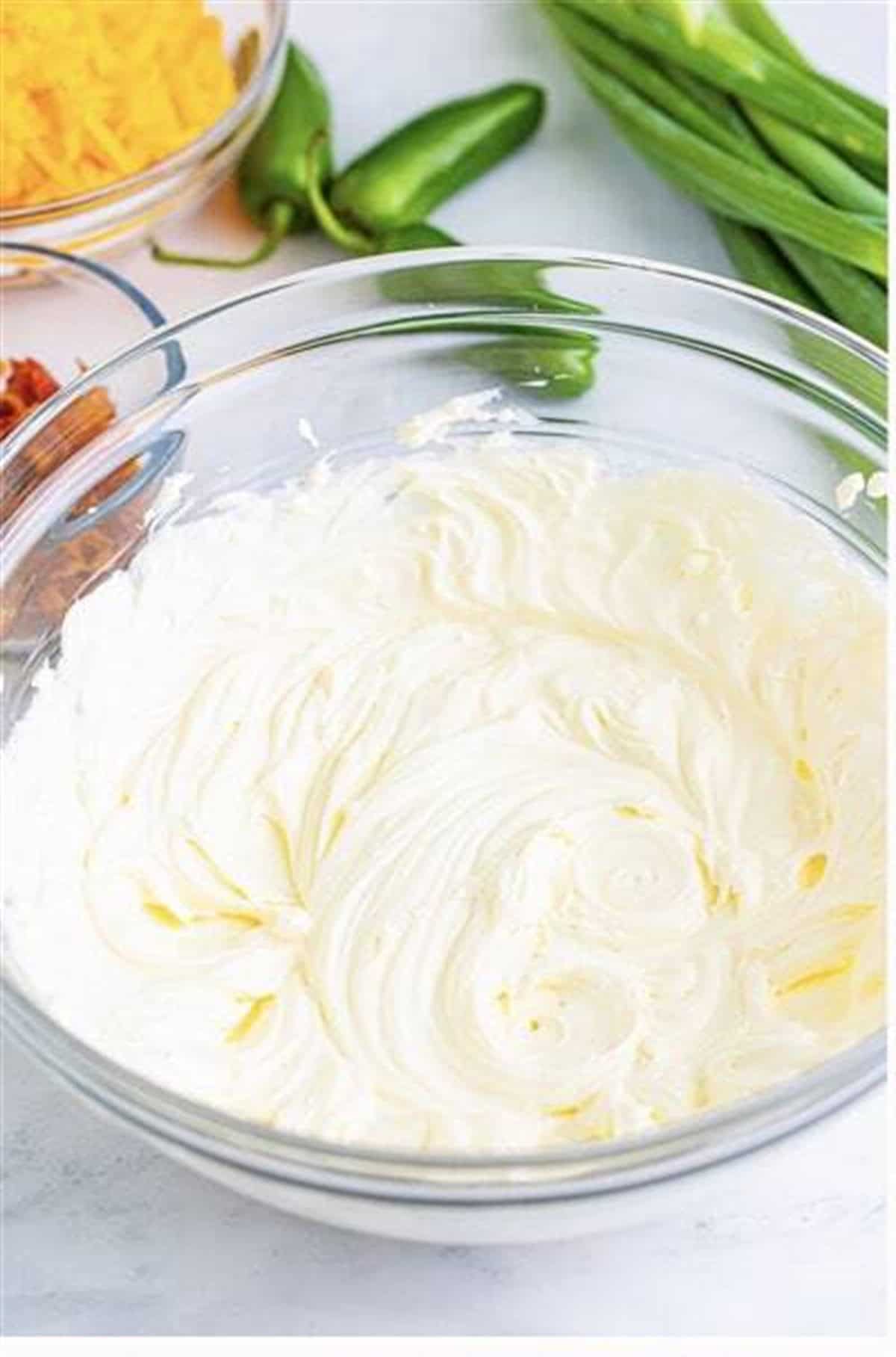 Cream cheese whipped smooth in a glass bowl for Easy Cream Cheese Pinwheels (Jalapeno Popper).
