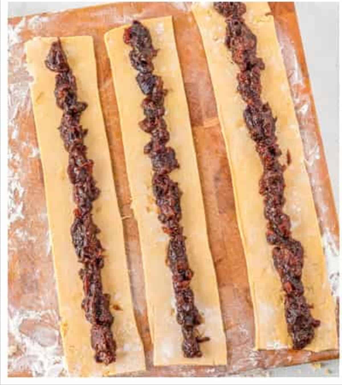 Fig filling spread down strips of rolled dough.