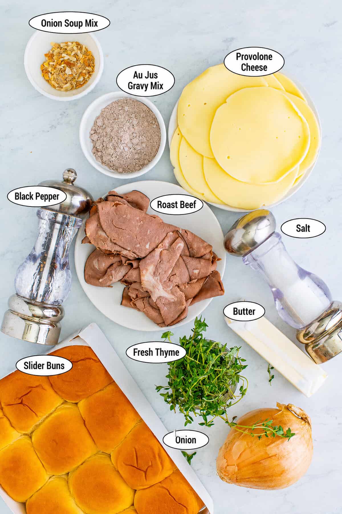Labeled ingredients for French Dip Sliders including Hawaiian rolls roast beef provolone cheese onions thyme butter and au jus mix.