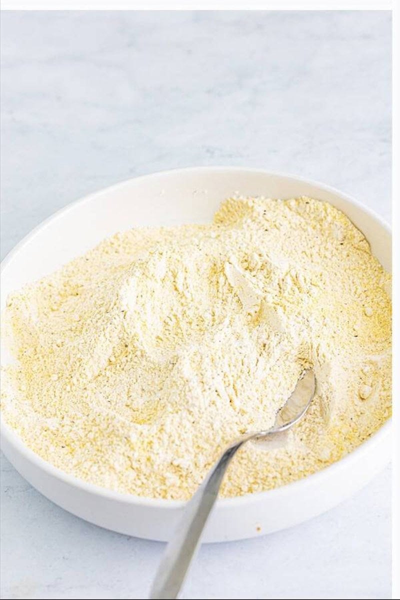 Cornmeal flour breading mix in a white bowl for fried catfish recipe.