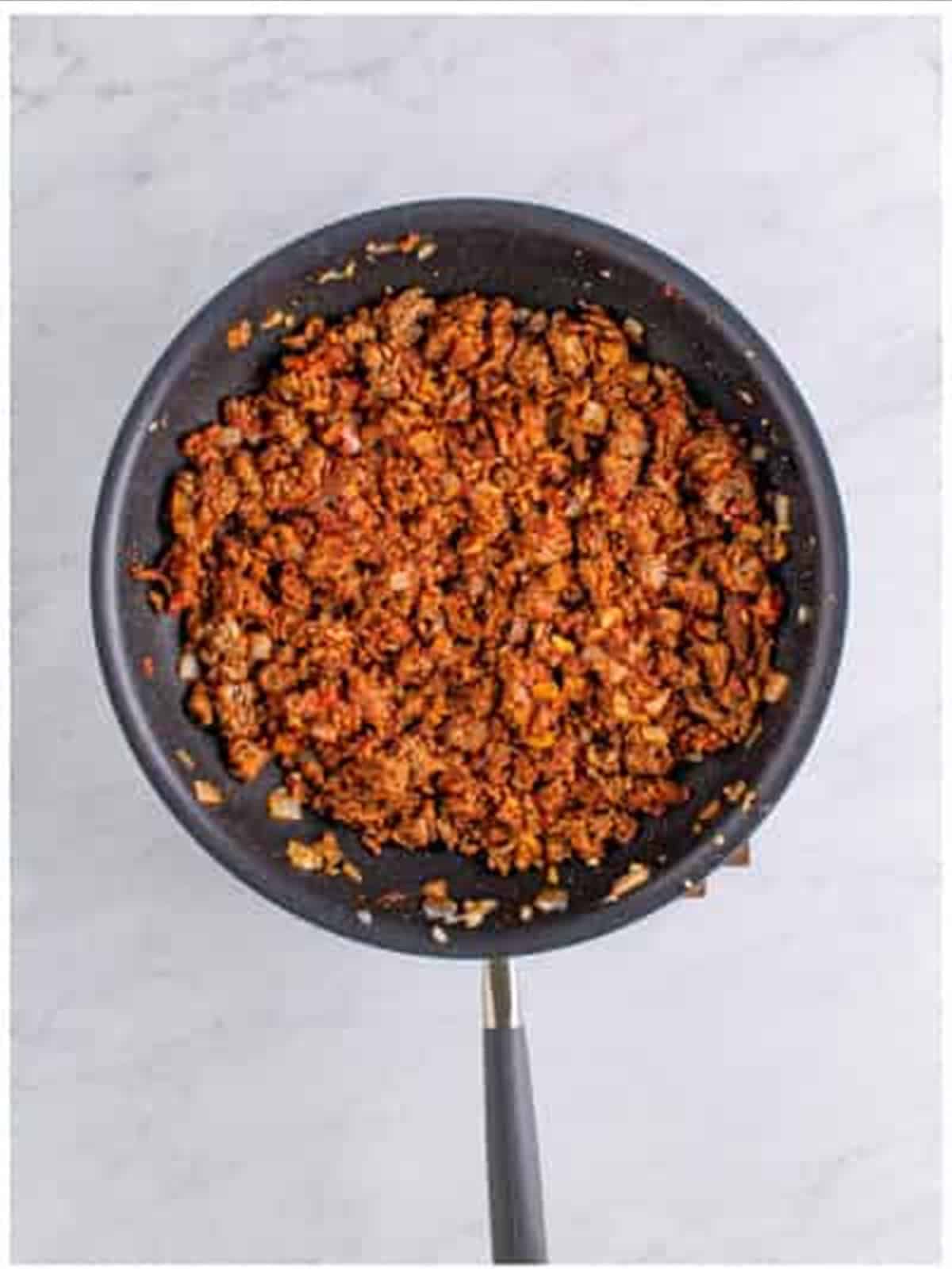 Seasoned ground beef cooked until the chili spices and tomato paste coat the meat.
