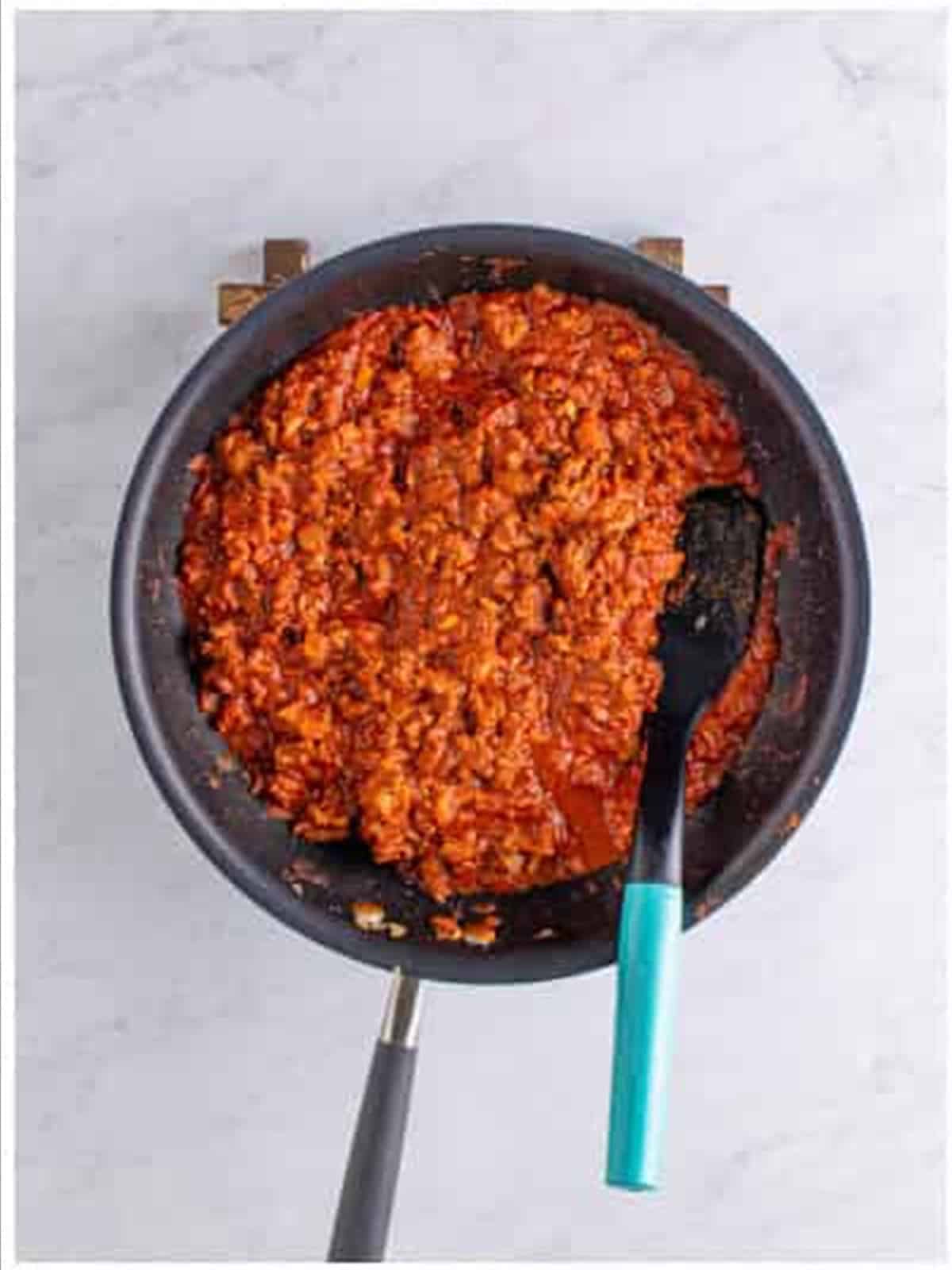 The Frito pie casserole chili simmered until thickened in the skillet.