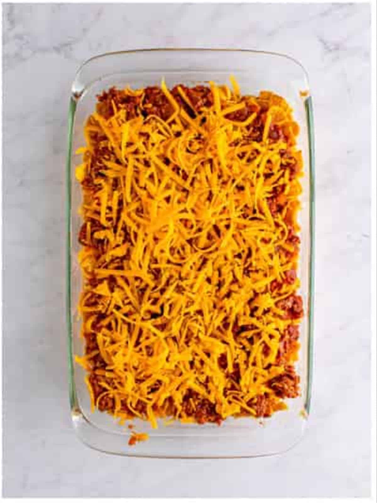 The Frito pie casserole topped with a final layer of cheddar before baking.