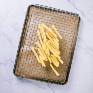 First fry of Homemade French Fries at 325 degrees then draining on a wire rack.