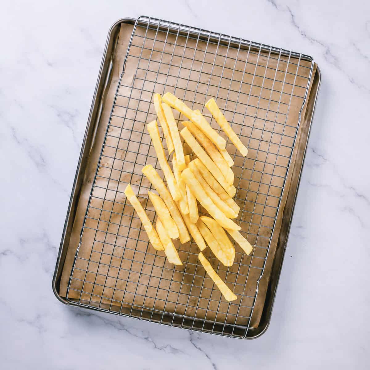 First fry of Homemade French Fries at 325 degrees then draining on a wire rack.