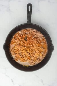 Coney Sauce Recipe partway through its simmer with a few tablespoons of water added to keep the texture smooth and spreadable.